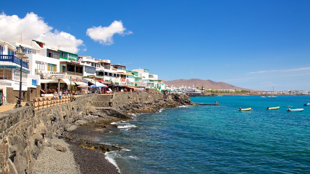 Playa Blanca showing boating, a coastal town and rocky coastline