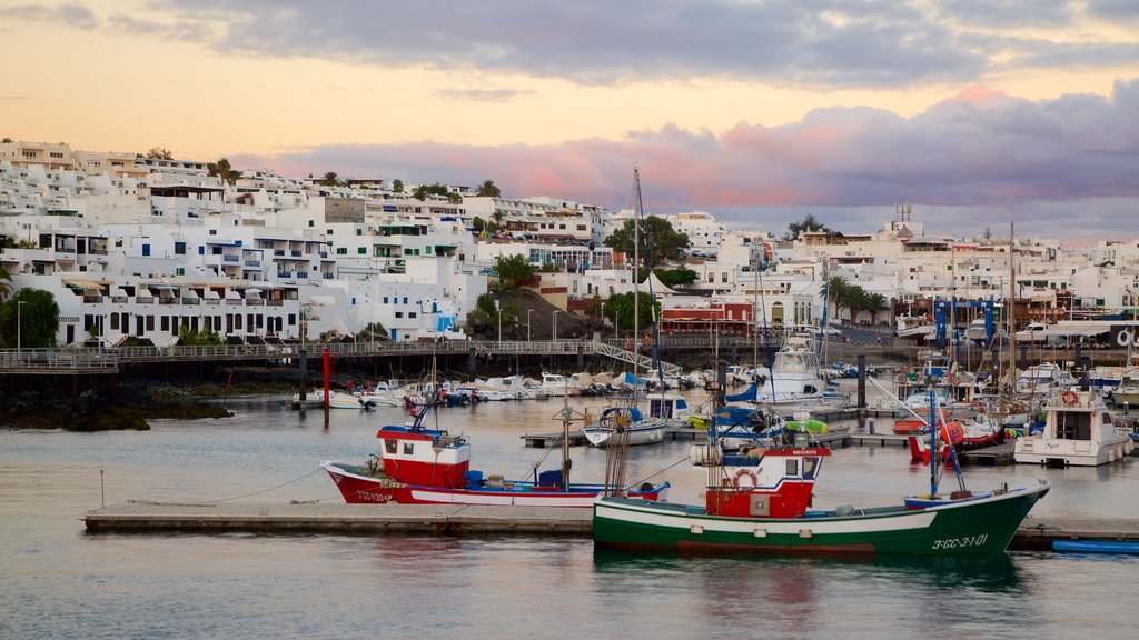 Puerto del Carmen ofreciendo botes, una ciudad costera y una bahía o un puerto