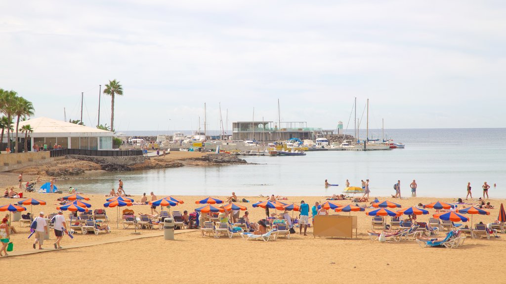 Caleta de Fuste showing a sandy beach, general coastal views and a bay or harbour