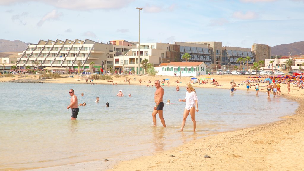 Caleta de Fuste que incluye una playa, arquitectura moderna y natación