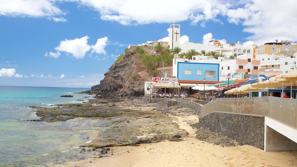 Morro del Jable mostrando litoral acidentado, uma praia e uma cidade litorânea