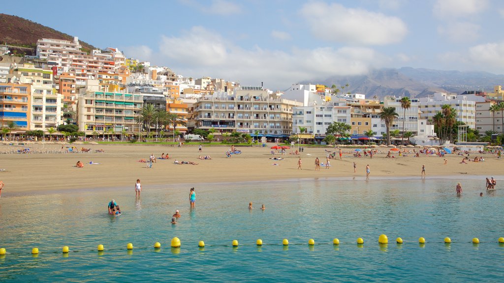 Los Cristianos que incluye natación, una playa y una ciudad costera