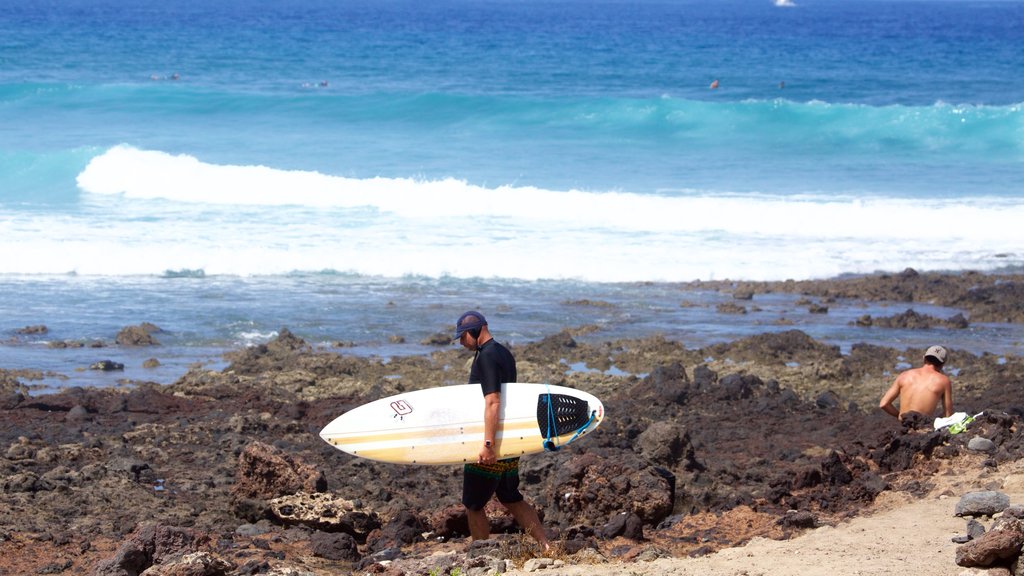 Playa de las Américas que incluye surf y costa escarpada y también un hombre