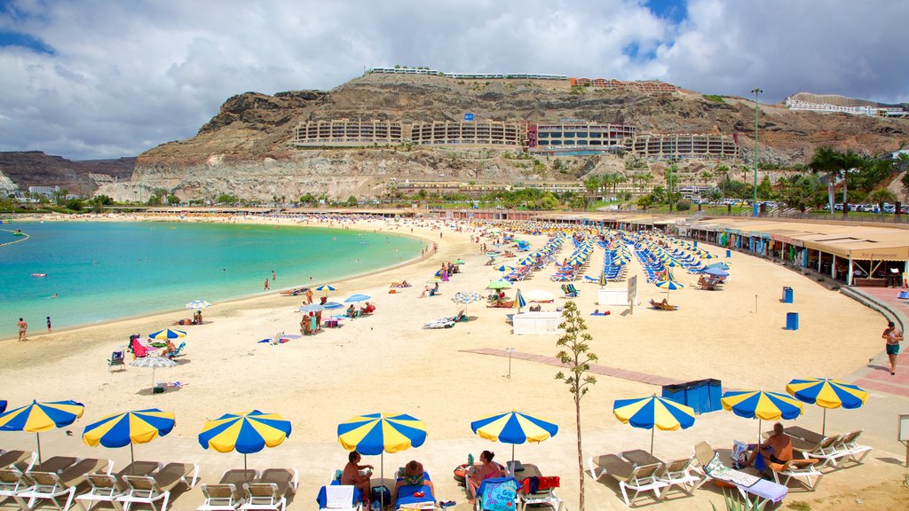 Plage d\'Amadores mettant en vedette une plage de sable, paysages côtiers et un hôtel ou un complexe de luxe