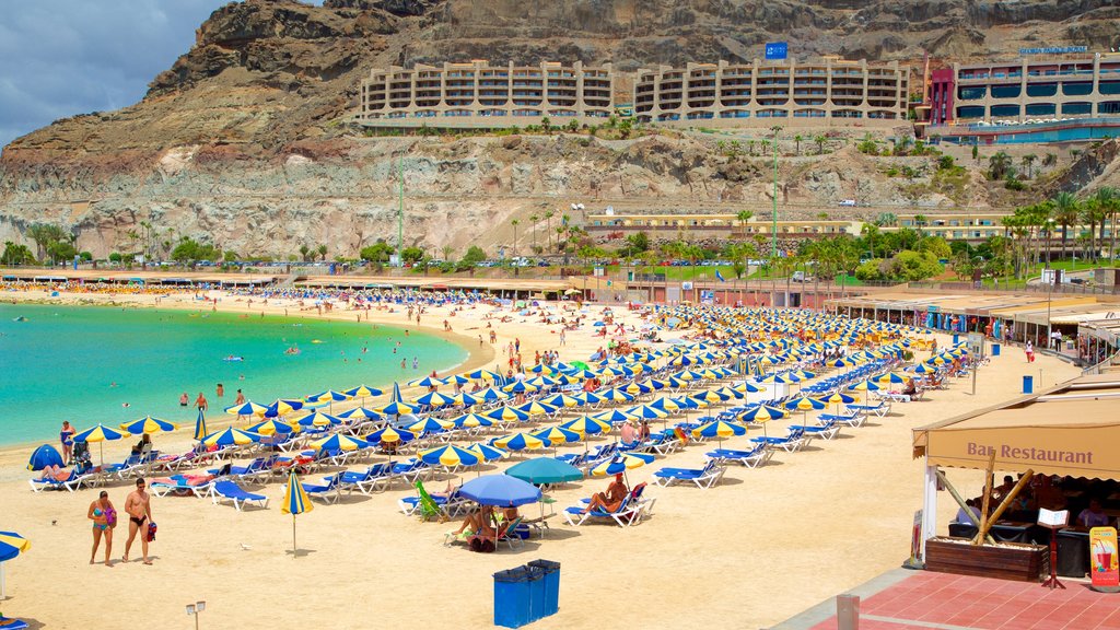 Playa de Amadores mostrando vista general a la costa, una playa de arena y un hotel de lujo o resort