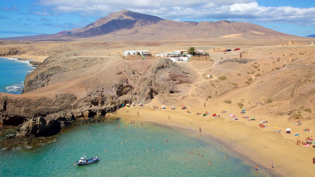 Praia Papagayo que inclui litoral rochoso, cenas tranquilas e uma praia de areia