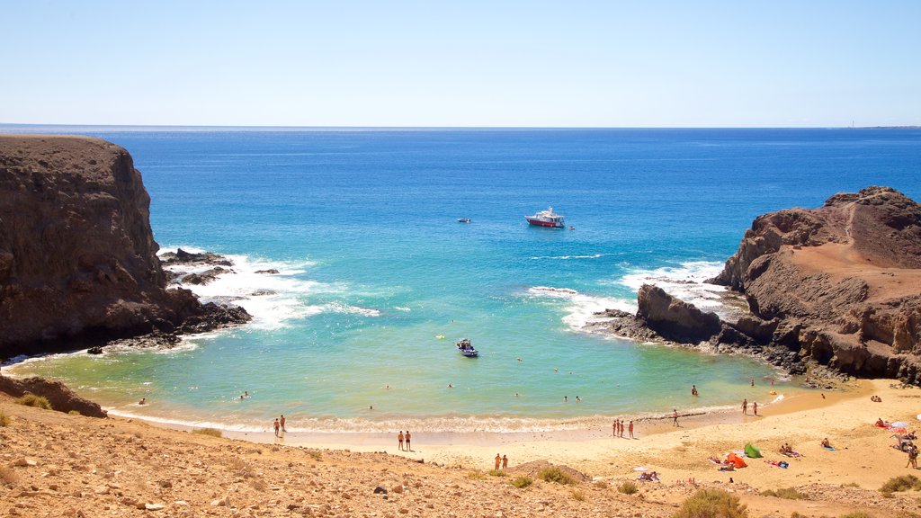 Papagayo Beach which includes a sandy beach, rugged coastline and a bay or harbour