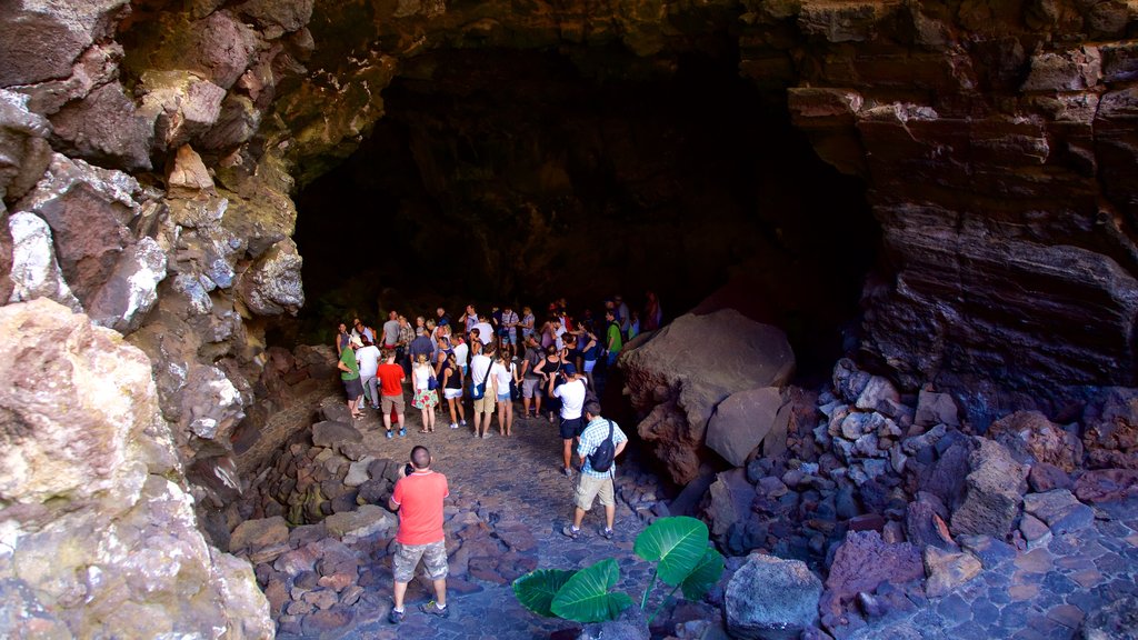 Cueva de los Verdes featuring caves as well as a large group of people