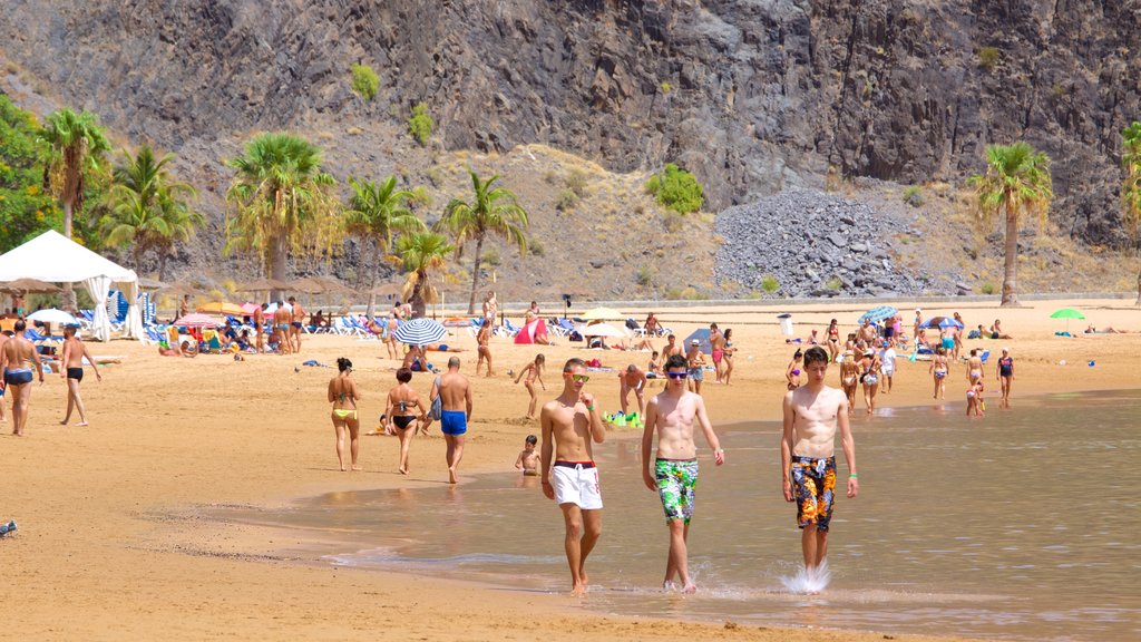 Teresitas Beach which includes general coastal views and a sandy beach as well as a large group of people