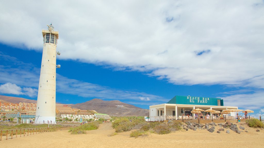 Jandia Lighthouse which includes a coastal town, a sandy beach and a lighthouse