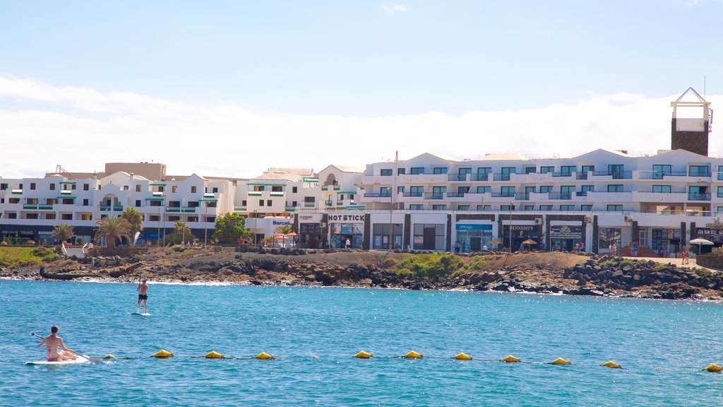 Las Cucharas Beach showing a coastal town, a sandy beach and kayaking or canoeing