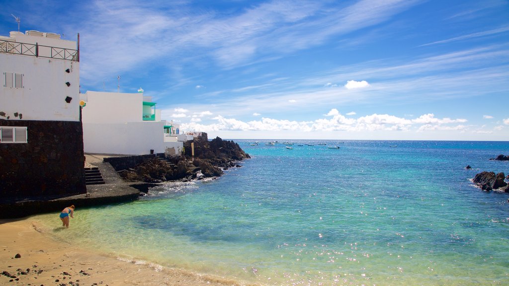 Lanzarote showing rocky coastline, a coastal town and a sandy beach