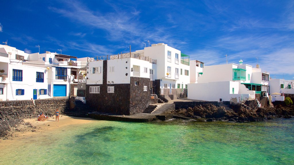 Lanzarote which includes a coastal town, rugged coastline and a sandy beach