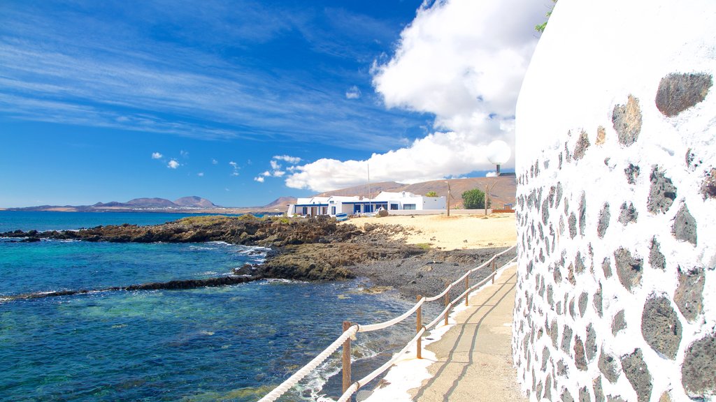 Lanzarote mostrando costa rocosa, una playa y vistas generales de la costa