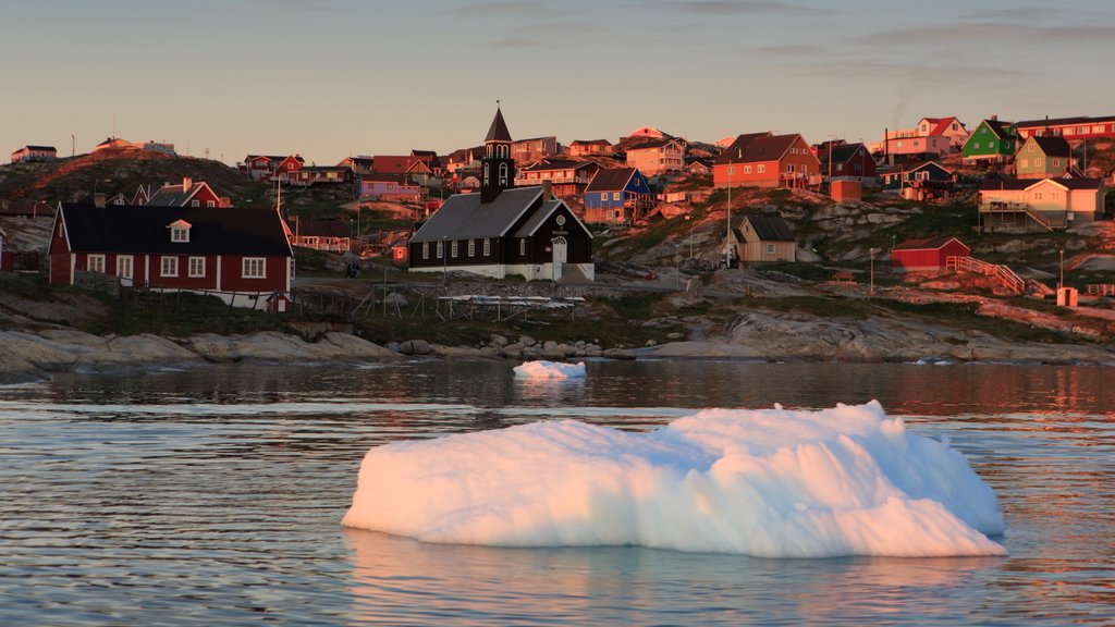 Ilulissat que incluye un atardecer, un lago o espejo de agua y una ciudad