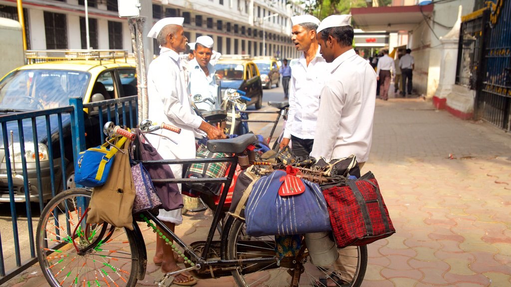 Mumbai caracterizando uma cidade e ciclismo assim como um pequeno grupo de pessoas