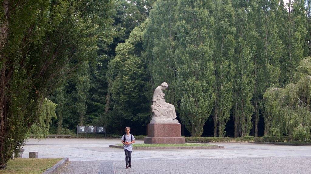 Berlin montrant une place publique et une statue ou une sculpture aussi bien que un enfant seul