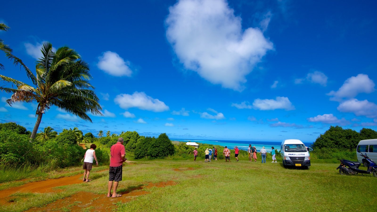 Aitutaki featuring general coastal views as well as a small group of people