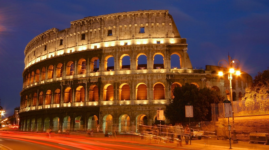 Coliseo ofreciendo escenas nocturnas, un monumento y elementos patrimoniales