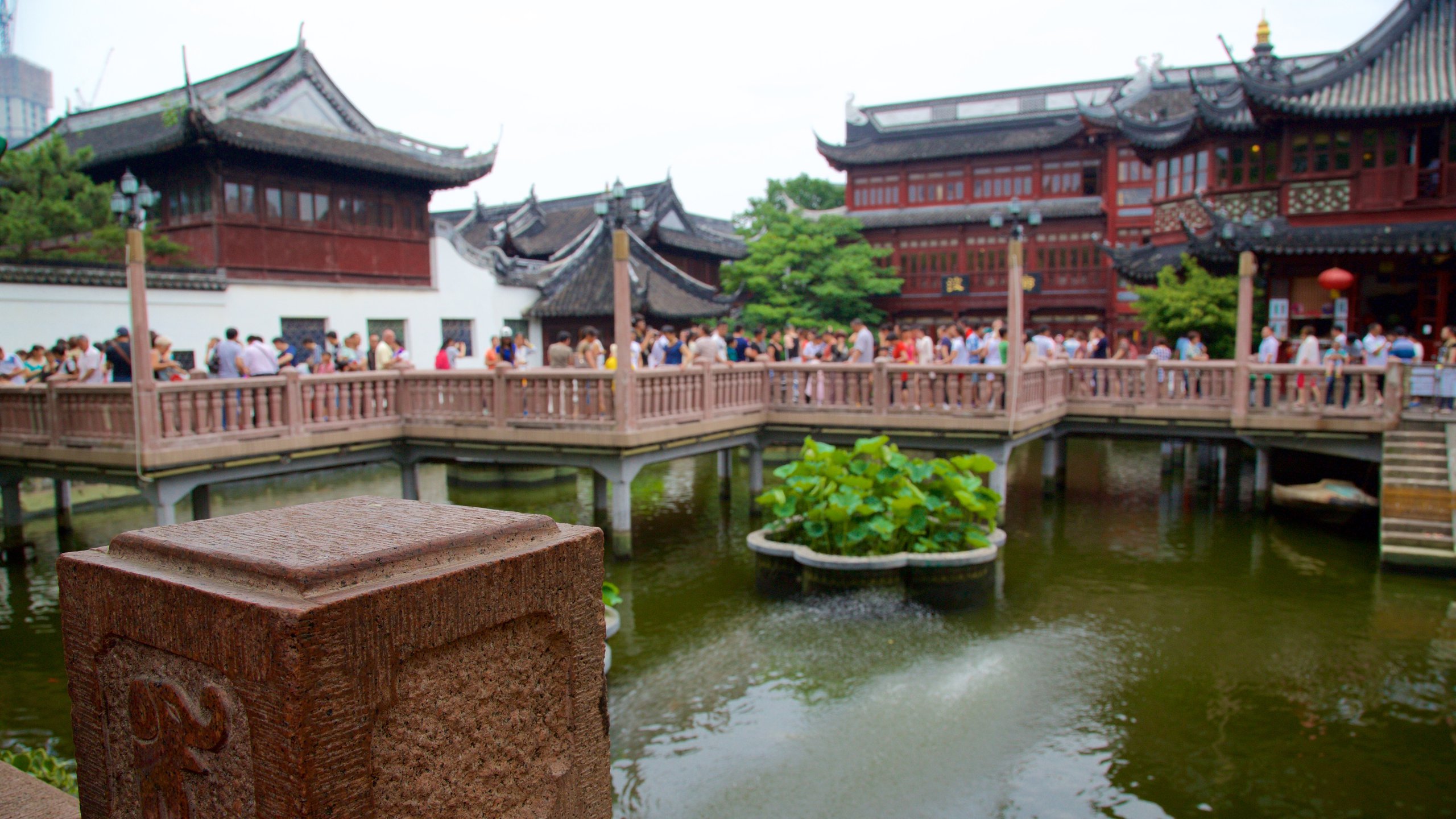 Yu Garden showing a pond and heritage elements as well as a large group of people