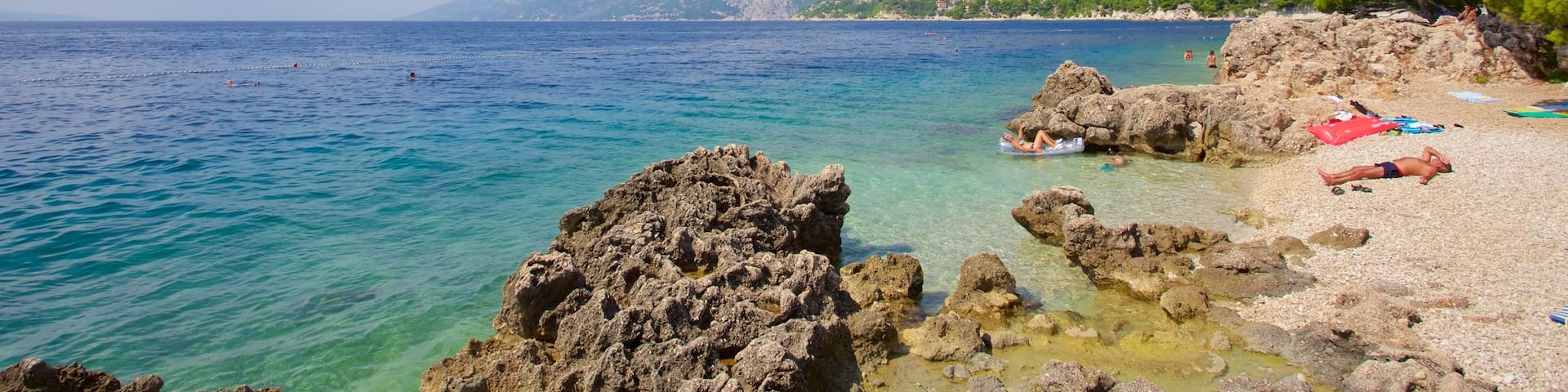 Strand von Brela mit einem Steinstrand und Berge sowie kleine Menschengruppe
