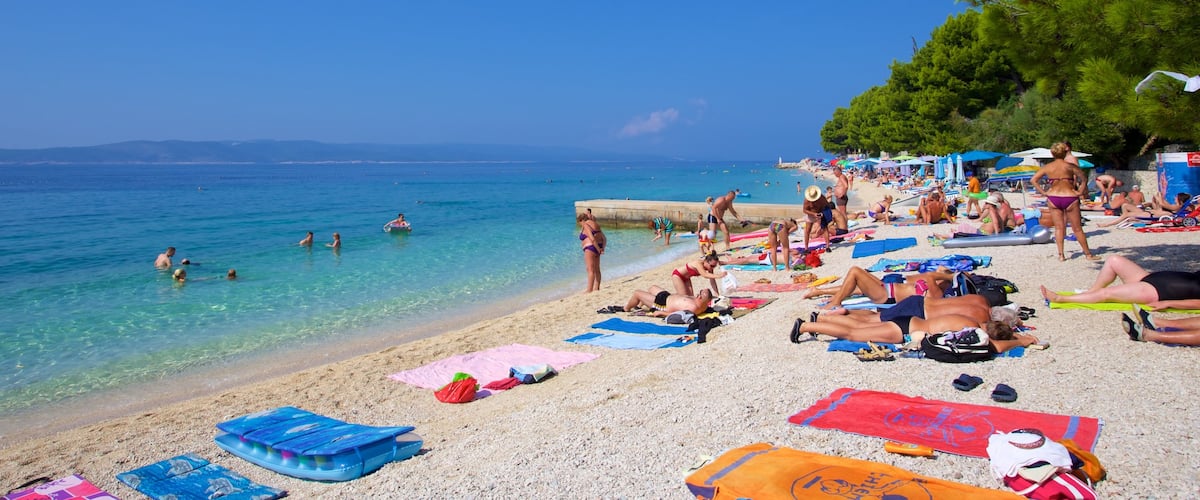 Playa Baska Voda mostrando una playa de guijarros y también un pequeño grupo de personas