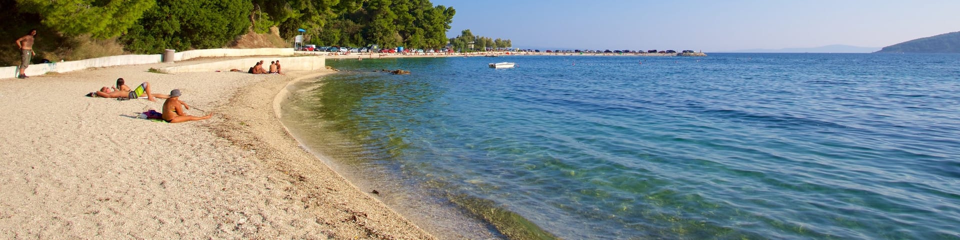 Kasuni Beach which includes general coastal views and a beach as well as a small group of people