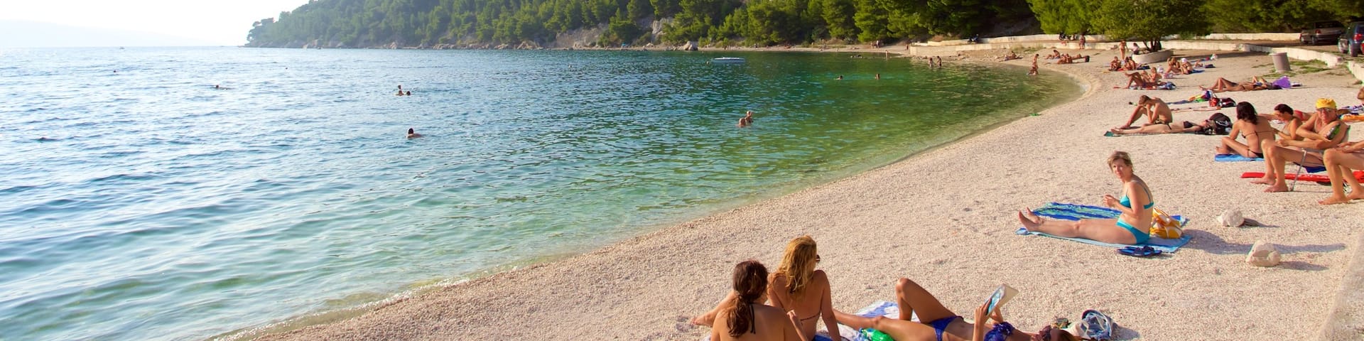 Kasuni Beach showing a beach and general coastal views as well as a large group of people