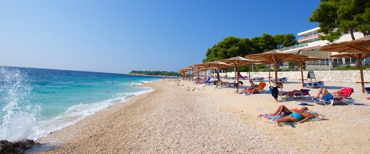Primosten Beach showing a pebble beach as well as a small group of people