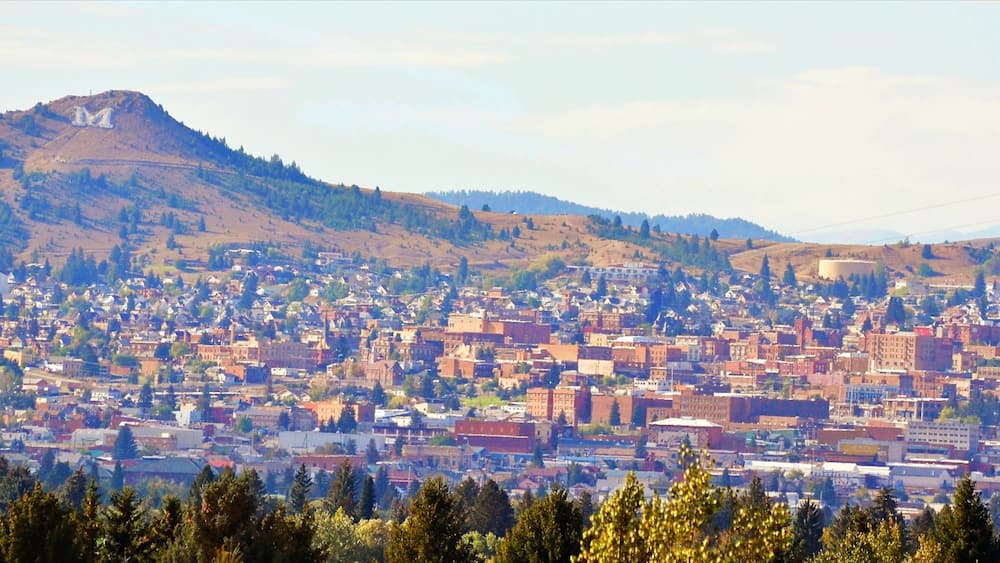 Butte showing a small town or village, a city and mountains