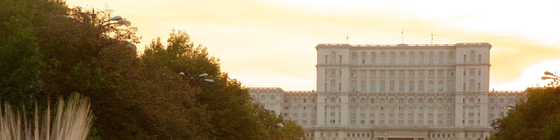 Palace of the Parliament featuring a sunset, a fountain and heritage architecture