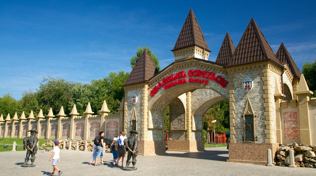 Tineretului Park which includes a statue or sculpture and rides as well as a small group of people