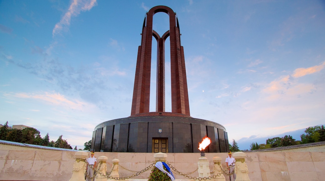 Carol Park showing a sunset and a monument as well as a small group of people