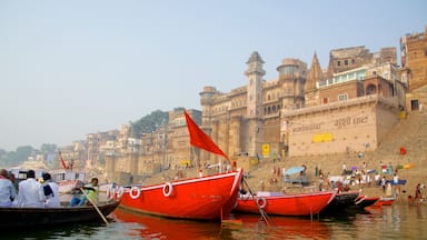 Varanasi som visar båtkörning, en hamn eller havsbukt och en kuststad