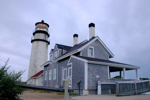 Cape Cod/Highland -majakka joka esittää majakka, yleiset rantanäkymät ja talo