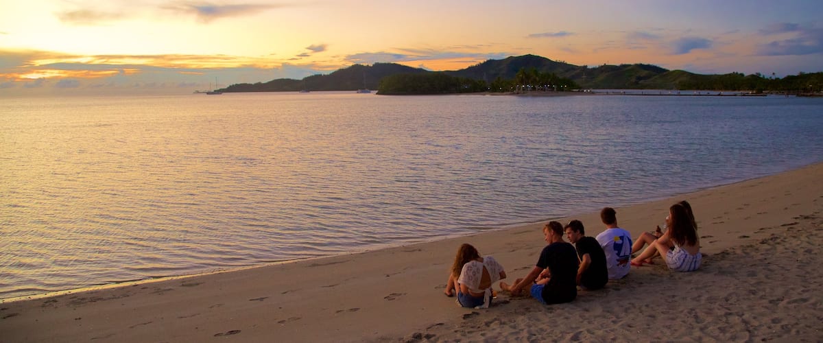 Musket Cove Marina showing a sunset, mountains and a sandy beach