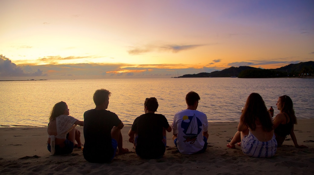 Musket Cove presenterar en solnedgång och en strand såväl som en liten grupp av människor