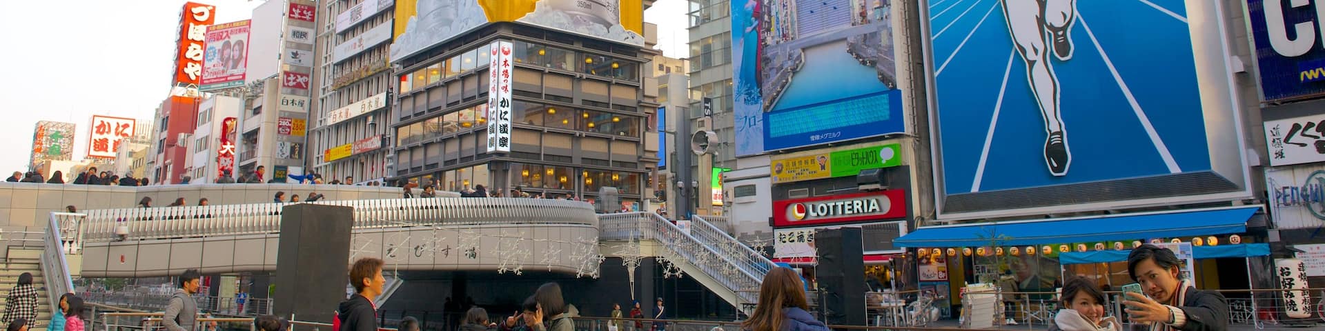 Dotonbori featuring city views and outdoor art as well as a large group of people