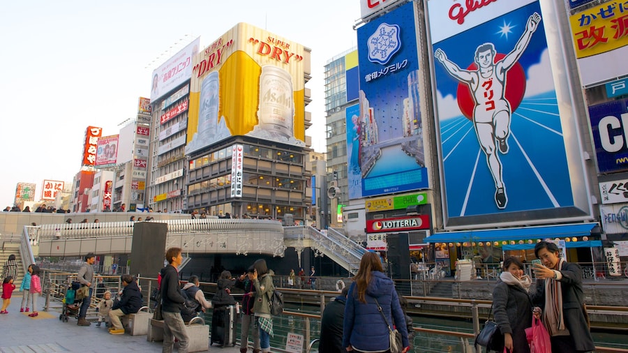 Dotonbori featuring city views and outdoor art as well as a large group of people