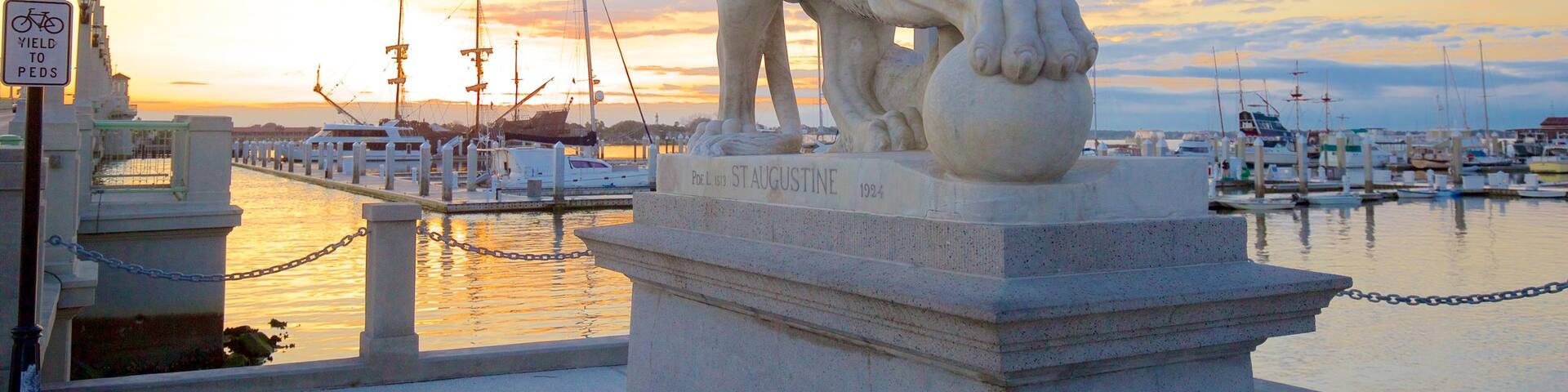 Bridge of Lions que incluye una puesta de sol, vistas generales de la costa y una estatua o escultura