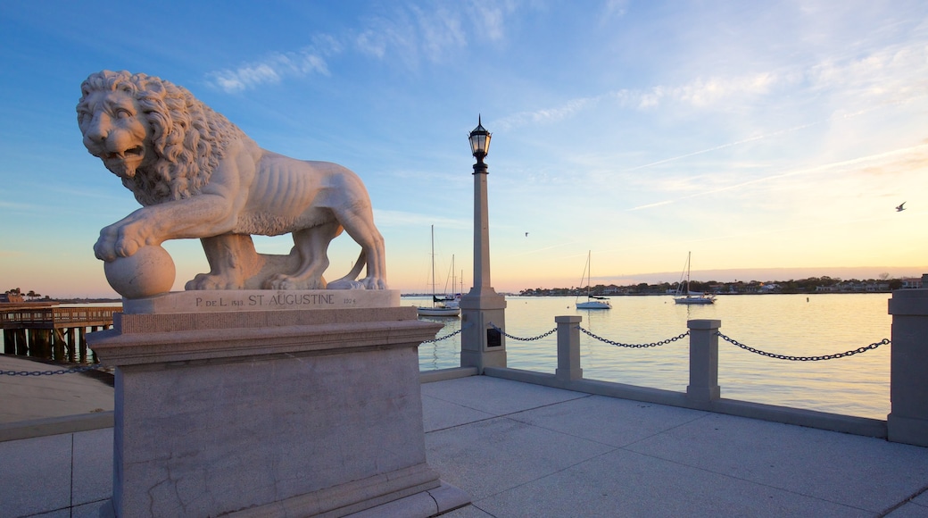 Bridge of Lions ofreciendo una estatua o escultura, una puesta de sol y vistas generales de la costa