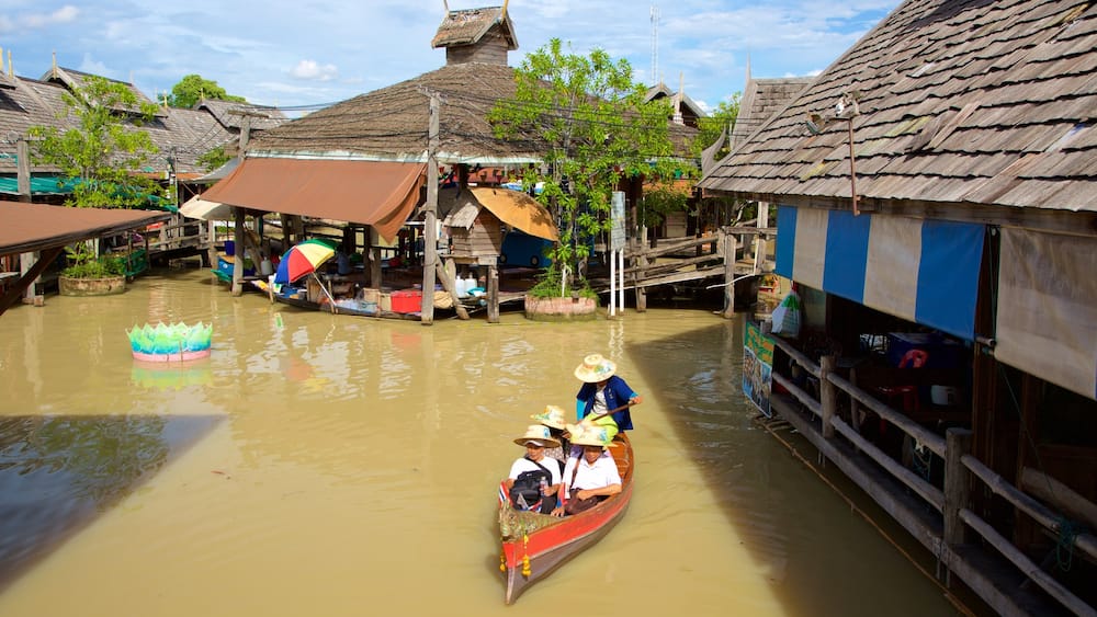 Pattaya Floating Market caracterizando um rio ou córrego e canoagem assim como um pequeno grupo de pessoas