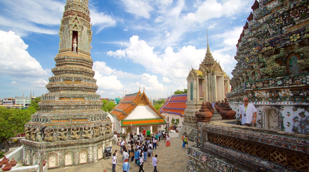 Wat Arun which includes a temple or place of worship as well as a large group of people