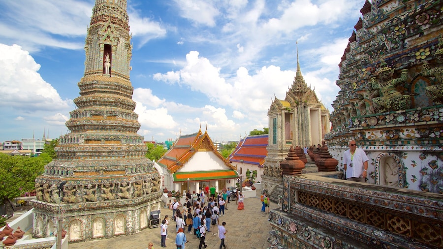 Wat Arun which includes a temple or place of worship as well as a large group of people