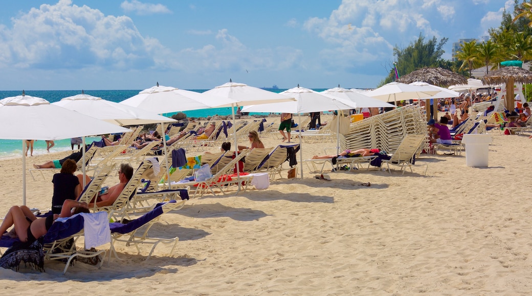 Lucaya Beach ofreciendo una playa de arena y un hotel de lujo o resort y también un gran grupo de personas