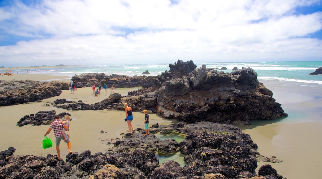 Sumner Beach featuring rugged coastline as well as a large group of people