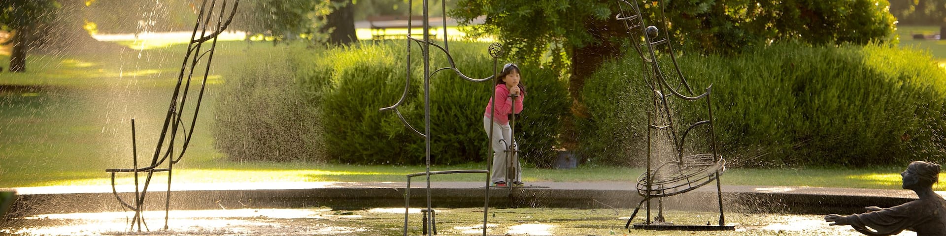 Christchurch Botanic Gardens featuring a fountain and a park as well as an individual child