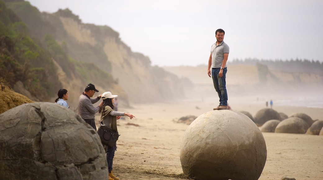 Moeraki Boulders showing rugged coastline as well as a small group of people