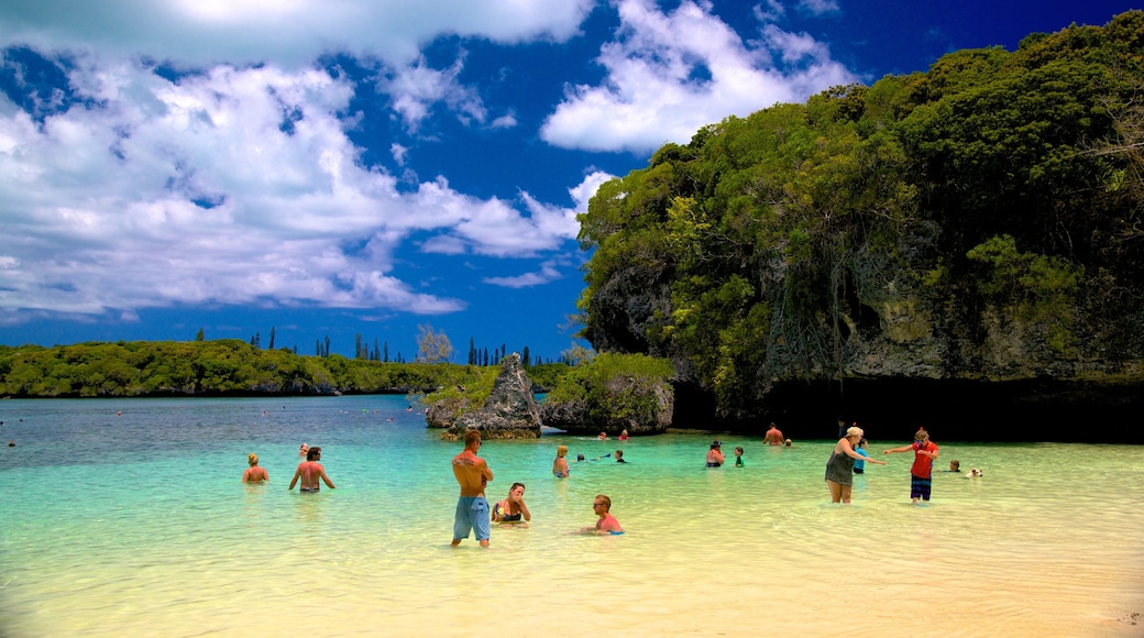 Kanumera Beach mostrando natação e paisagens litorâneas assim como um grande grupo de pessoas