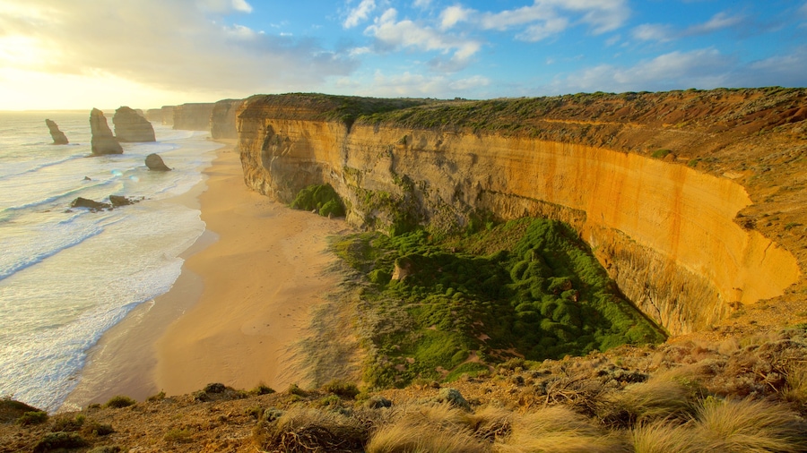 Twelve Apostles ofreciendo una garganta o cañón, costa escarpada y un atardecer